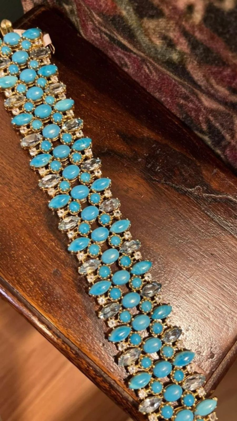 Close-up of a wide sterling silver bracelet densely set with multiple rows of oval and round Persian turquoise cabochons, interspersed with clear, faceted blue aquamarine stones.