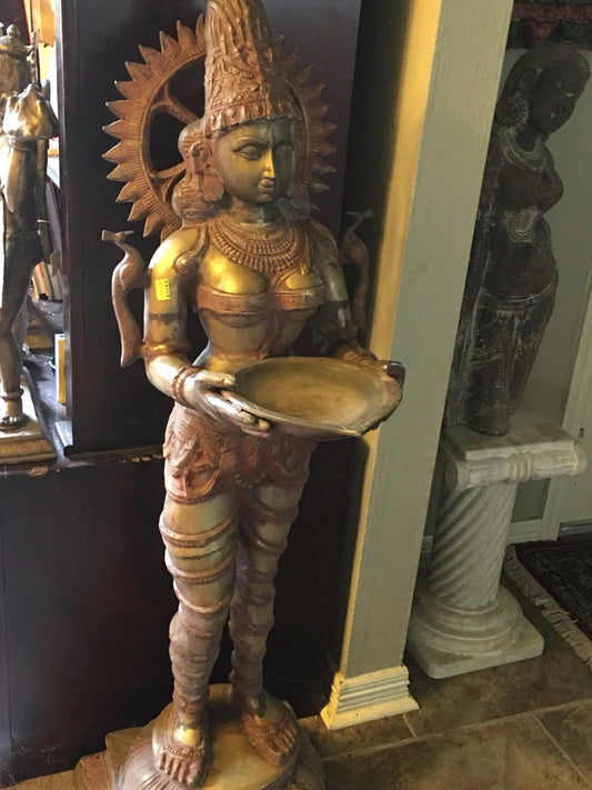 Traditional brass Lakshmi idol with oil lamp in both hands