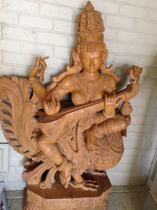 Hand-carved Saraswati statue holding veena and scripture
