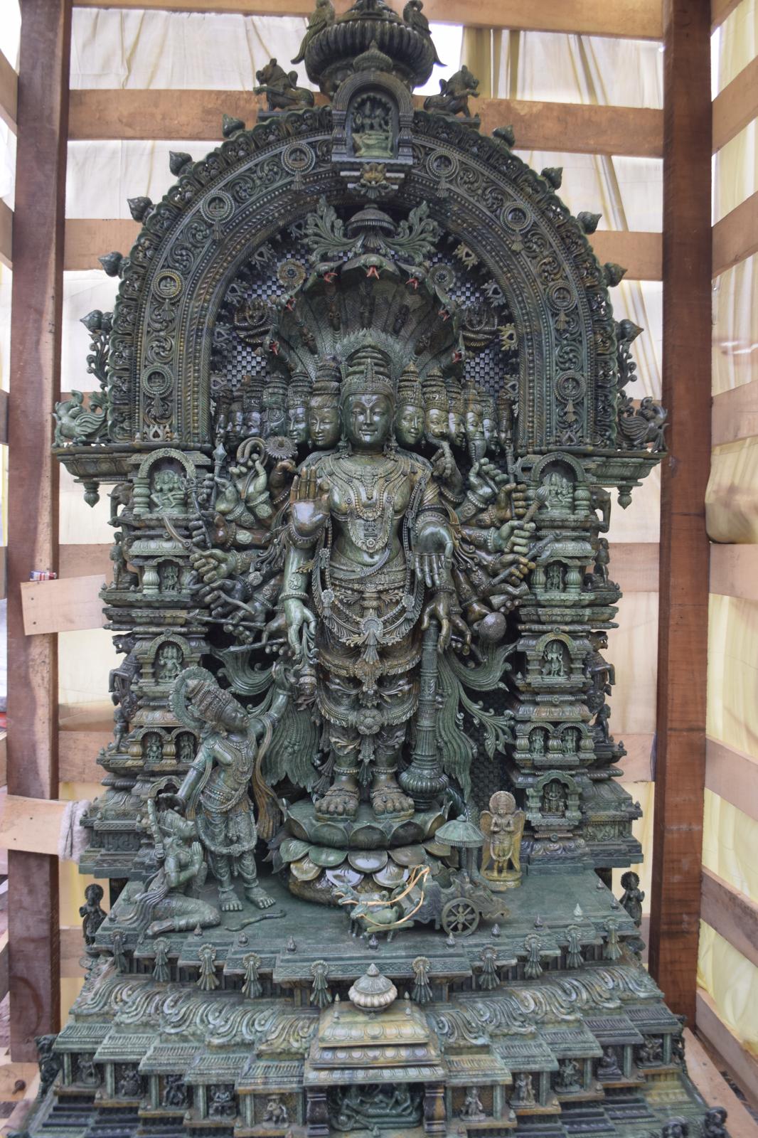 Hand-carved Vishwarupa sculpture in green serpentine stone featuring multiple faces, arms, and ornate arch – 9.5 ft tall spiritual Hindu deity statue by Zarposh India
