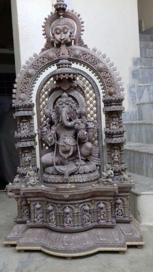 Hand-carved red sandstone Ganesha statue with temple arch and miniature deity carvings