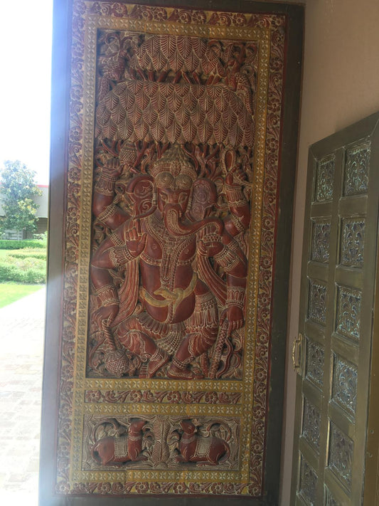 Intricately hand-carved wooden Ganesha wall panel with floral border